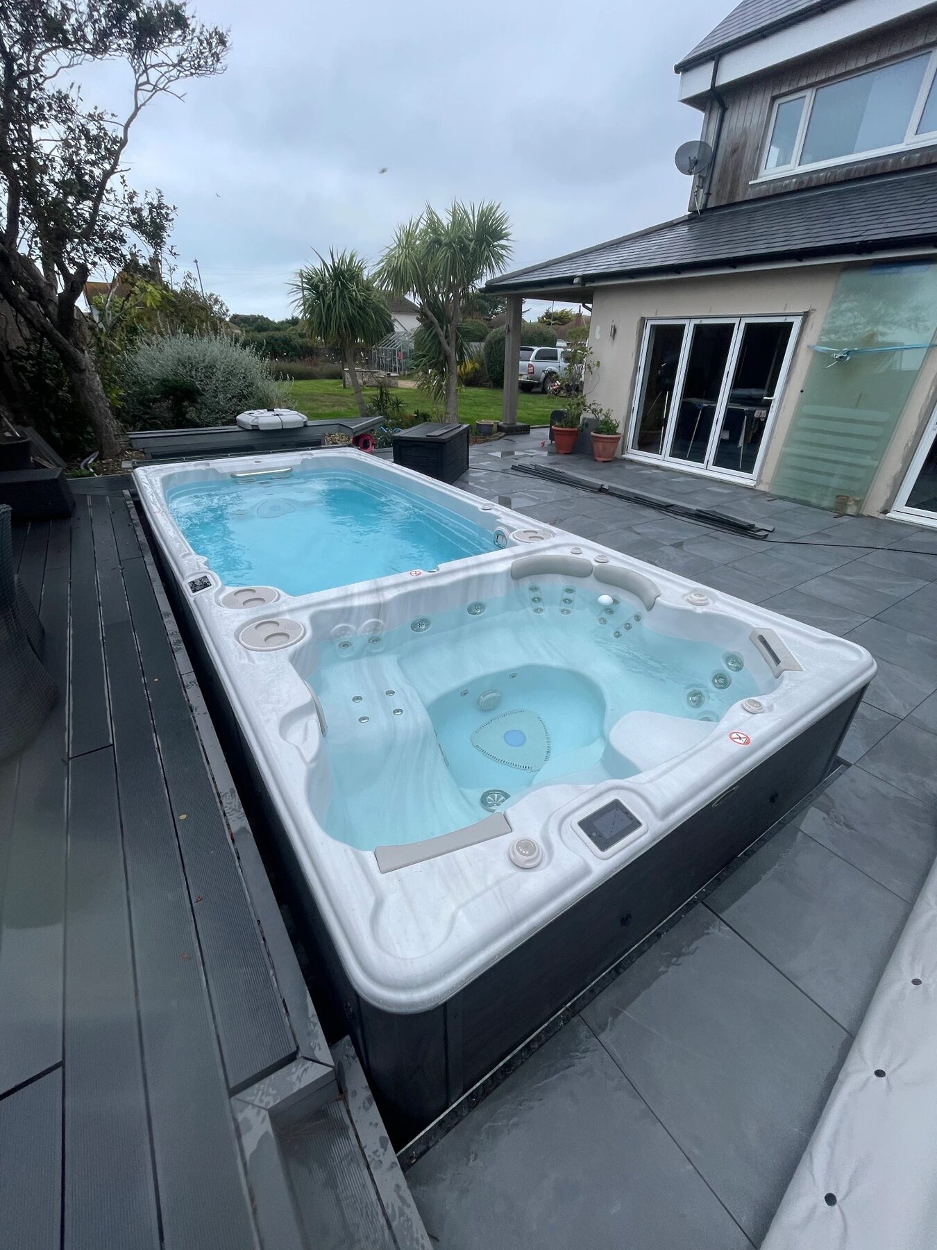 Swim spa installed on a tiled terrace beside a Sussex home