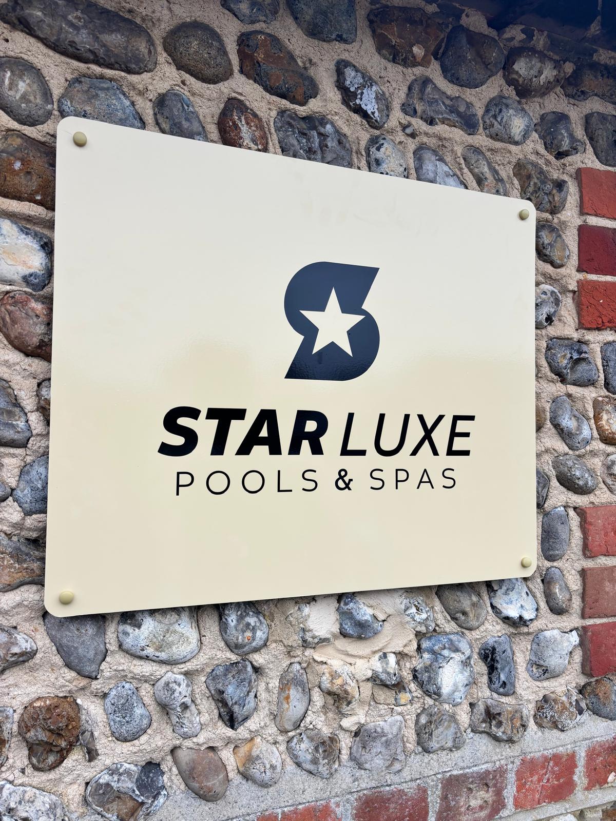 StarLuxe Pools & Spas sign on a flint wall at the Donnington showroom